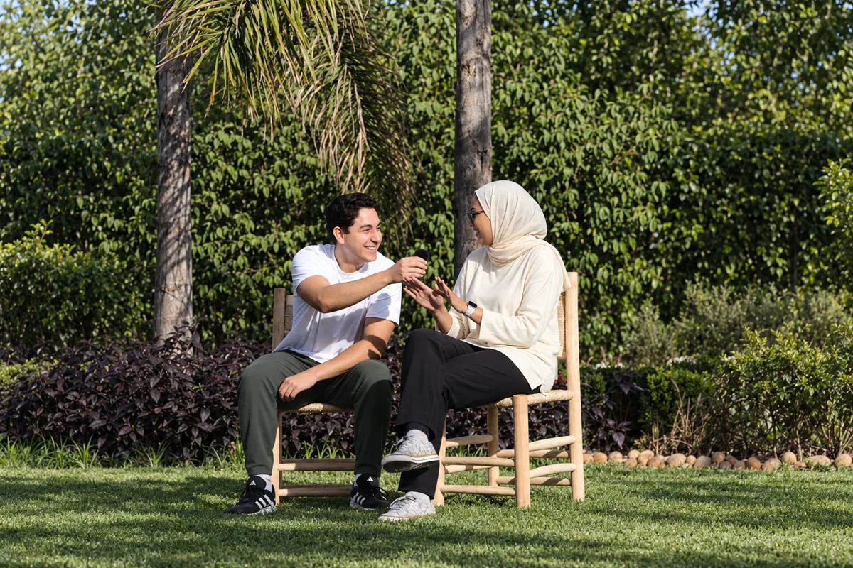 Ibrahim échange avec une participante assise dans le jardin